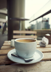 Coffee in a cup and saucer on a table outside