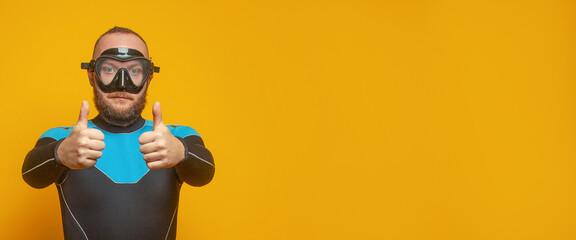 Closeup portrait of diver diving guy showing thumb up against colorful orange studio wall background
