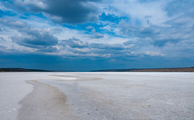Rain cumulus clouds over the dry and self-sedimentary table salt covered muddy bottom