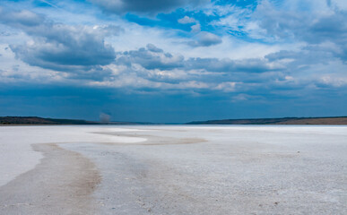 Rain cumulus clouds over the dry and self-sedimentary table salt covered muddy bottom
