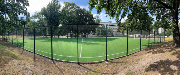 Obraz premium Panorama of an empty school soccer field. Football stadium near the school