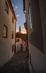 Dreamy morning view through the tiny street to the historical city Cesky Krumlov with magical sky in south of Bohemia, Europe.