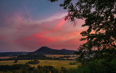 Romantic sunset view in northern Bohemia. Sky is full of colors and clouds fluffy and pink.