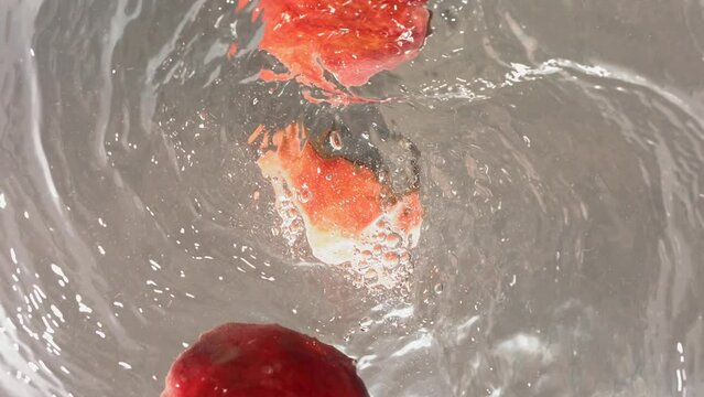 Super Slow Motion Shot of Fresh Peaches Falling into Water Whirl