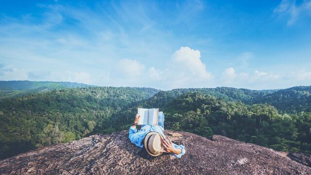Asian man travel relax in the holiday. sleep relax read books on rocky cliffs. On the Moutain. In Thailand
