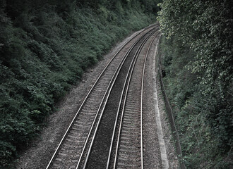 Fototapeta premium Railway double tracks in the countryside for a dark background presentation linked to movement and transportation for strong business success.