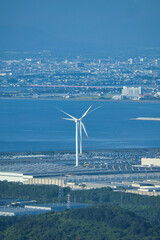 海沿いに立ち潮風を受ける風力発電の風車