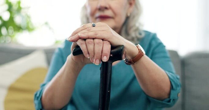 Hands, cane and senior woman with walking stick for balance, retirement and mobility support on a couch or sofa. Closeup, Aid and elderly person with disability, dementia or chronic arthritis