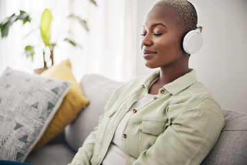 Black woman, listening and meditation podcast on headphones in home, living room or peace on sofa...