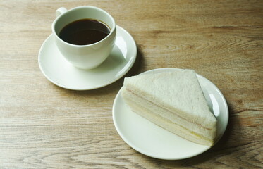 ham cheese sandwich on plate and black coffee cup