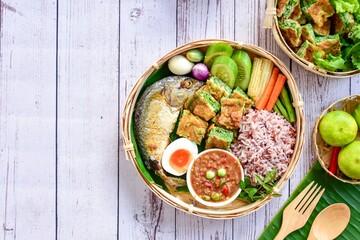 Thai spicy shrimp paste dipping sauce ( Nam prik kapi )with cooked  rice and fried mackerel fish and fried egg with climbing wattle and vegetable set. top view food , free copy space