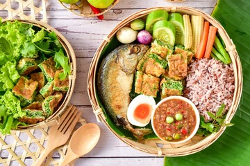Thai spicy shrimp paste dipping sauce ( Nam prik kapi )with cooked  rice and fried mackerel fish and fried egg with climbing wattle and vegetable set. top view food , free copy space