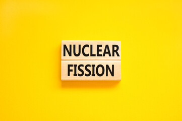 Nuclear fission symbol. Concept words Nuclear fission on beautiful wooden blocks. Beautiful yellow...