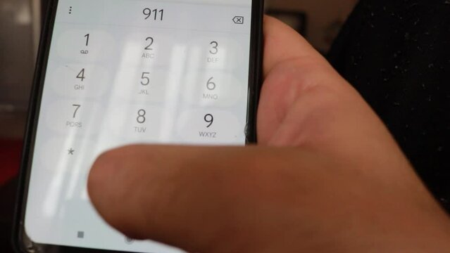 Domestic call with fingers dialing the emergency number 911 on a smartphone screen in Spanish for a case of domestic violence