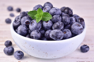 Blueberries in a bowl, on a white background. Close-up.
