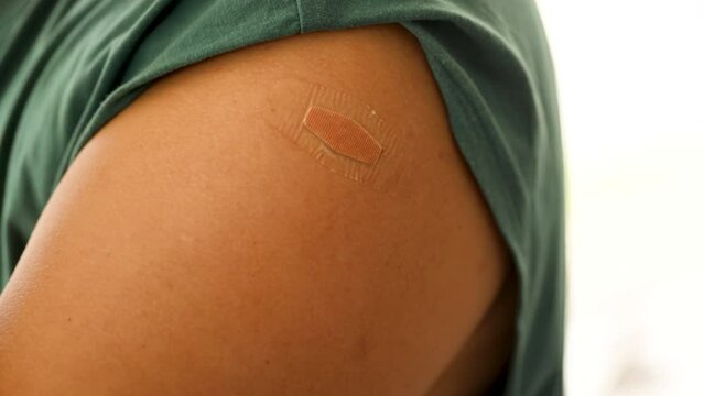 Arm with an adhesive bandage. Plaster is attached to the arm. Concept for first aid after coronavirus (COVID-19) vaccination. Vaccination Saves Lives. woman showing adhesive plaster on arm