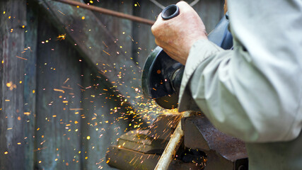 Pipe cutting with a circular grinder. A man's hand, cuts pieces of pipe with a grinder. power tool,...