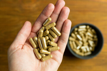 Herbal dietary supplements held in hand, body support, drug dosage
