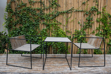 Wooden table and chairs on bamboo wall of coffee cafe patio