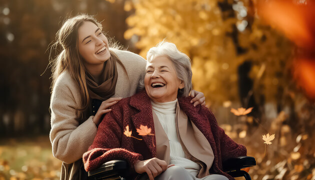 Young woman with her mother in wheelchair in park wearing winter clothing and walking