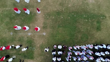 Gorontalo, Indonesia - August 17, 2023: Aerial view of Indonesian flag lowering ceremony witnessed by villagers. Indonesia Independence Day
