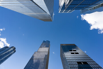 Fototapeta na wymiar Looking Up at Modern Glass Skyscrapers and a Blue Sky at Hudson Yards in New York City