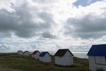 Fototapeta na wymiar Beach cabins and seashore in Gouville sur Mer, Manche, Normandy, France in various lights