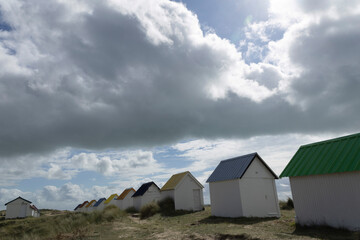 Beach cabins and seashore in Gouville sur Mer, Manche, Normandy, France in various lights