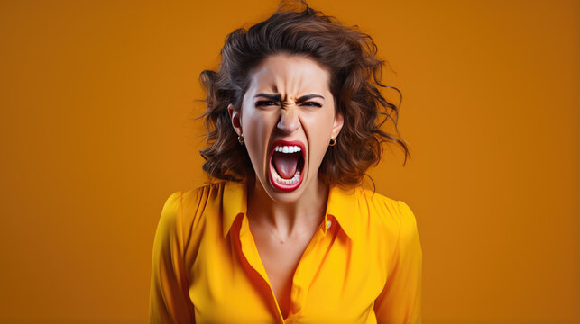 Angry woman screams against orange background