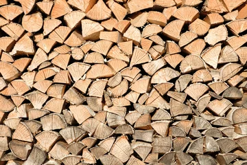Keuken spatwand met foto firewood wooden row as background or pattern. Background of stacked chopped wood logs. Pile of wood logs ready for winter. Wooden stumps, firewood stacked in heap © Aleksandr Matveev