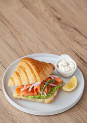 Croissant with smoked salmon, avocado and lemon