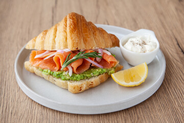Croissant with smoked salmon, avocado and lemon