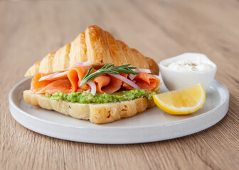 Croissant with smoked salmon, avocado and lemon