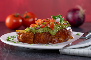 Challah Avocado Toast with diced tomatoes and onions.