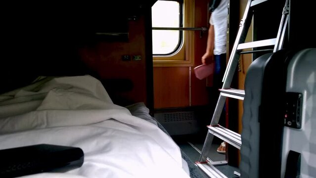 Sleep on the night train. Lie down shelf. The passenger is traveling. Recumbent seat compartment in the train Warsaw - Kyiv. View from inside Ukrainian high speed train.