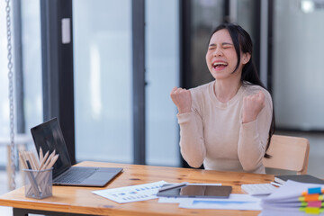 Female Entrepreneur. Cheerful of Asian Businesswoman Working On document and Laptop In Modern Office. Empty Space