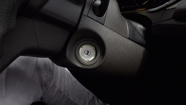 Stopping the car engine. The driver's hand takes out the car key from the ignition