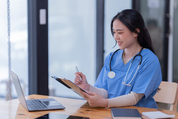 Portrait of Asian female doctor working on the desk and smiling