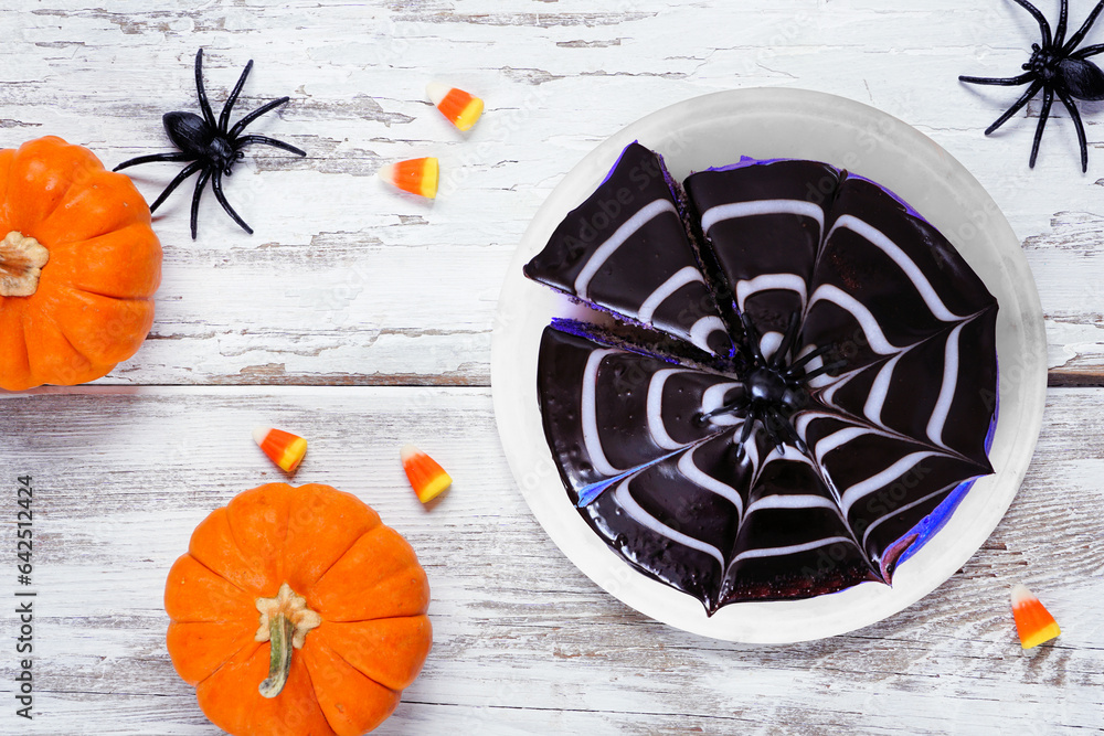 Poster halloween spider web cake. above view table scene over a white wood background.