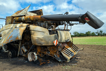 Fototapeta na wymiar une moissonneuse batteuse détruite par le feu dans un champ de la campagne française en Europe