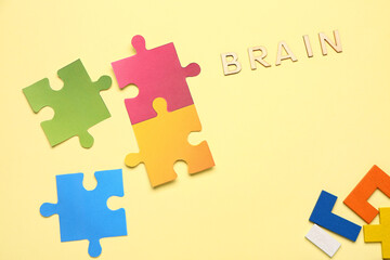 Word BRAIN with puzzle pieces and blocks on yellow background. Logic concept