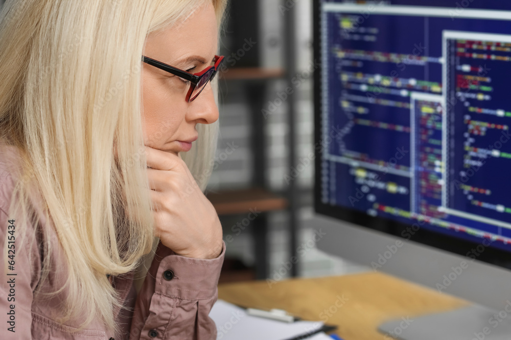 Poster mature female programmer working with computer at table in office, closeup
