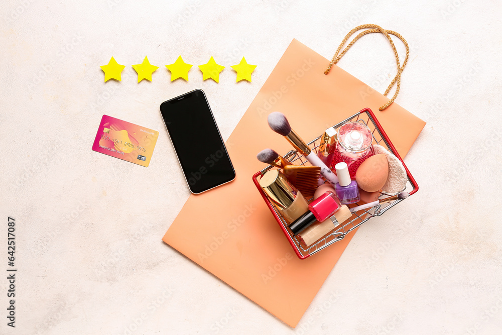 Wall mural Five stars, credit card, mobile phone, bag and shopping basket with makeup products on light background. Customer experience concept