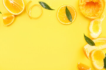 Frame made of orange slices with leaves on yellow background