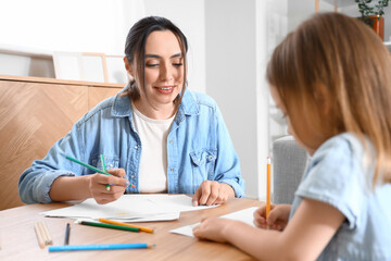 Young woman with her little daughter drawing at home