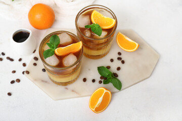 Glasses of tasty orange espresso on light background