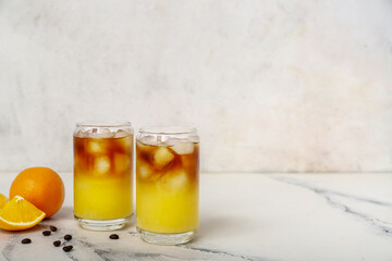 Glasses of tasty orange espresso on white table