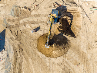 excavator on construction site digging and dumping dirt