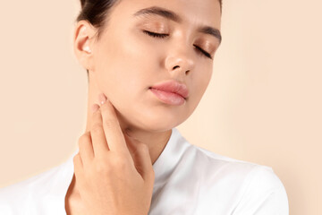 Young woman with beautiful lips on beige background, closeup