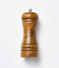 Wooden pepper mill on a white background, made of wood and has a metal handle on top